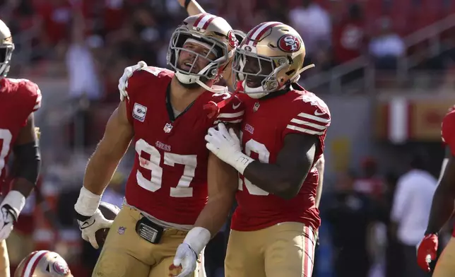 San Francisco 49ers defensive end Nick Bosa, left, is congratulated by linebacker Tatum Bethune (48) after Bosa sacked and recovered a fumble by New England Patriots quarterback Jacoby Brissett during the second half of an NFL football game in Santa Clara, Calif., Sunday, Sept. 29, 2024. (AP Photo/Jed Jacobsohn)