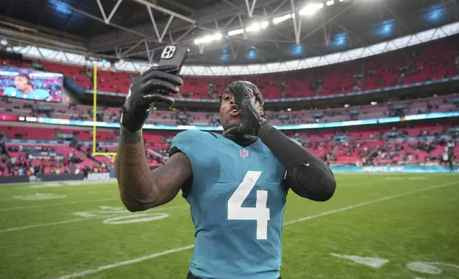 Jacksonville Jaguars running back Tank Bigsby uses his cell phone after an NFL football game against the New England Patriots, Sunday, Oct. 20, 2024, in London. (AP Photo/Kin Cheung)