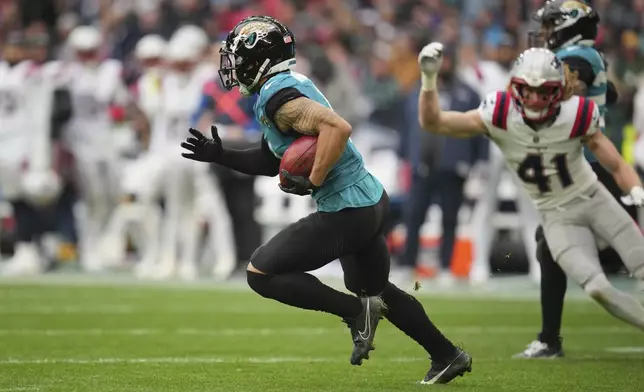 Jacksonville Jaguars' Parker Washington breaks through the New England Patriots defense for a 96-yard punt return for a touchdown during the first half of an NFL football game, Sunday, Oct. 20, 2024, in London. (AP Photo/Kin Cheung)