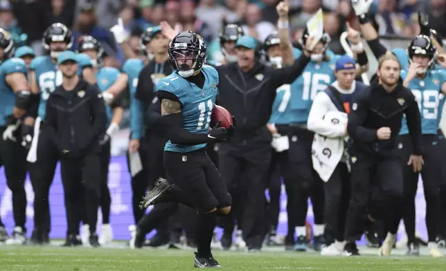 Jacksonville Jaguars wide receiver Parker Washington (11) returns a punt for a 96-yard touchdown during the first half of an NFL football game against the New England Patriots, Sunday, Oct. 20, 2024, in London. (AP Photo/Ian Walton)