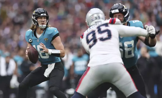 Jacksonville Jaguars quarterback Trevor Lawrence looks for a receiver during the first half of an NFL football game against the New England Patriots, Sunday, Oct. 20, 2024, in London. (AP Photo/Ian Walton)