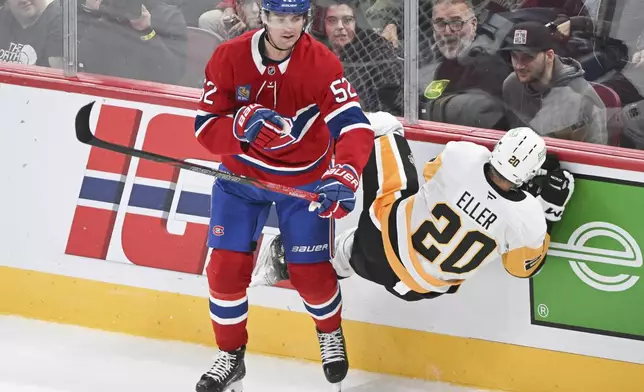 Montreal Canadiens' Justin Barron (52) upends Pittsburgh Penguins' Lars Eller (20) during the first period of an NHL hockey game in Montreal, Monday, Oct. 14, 2024. (Graham Hughes/The Canadian Press via AP)