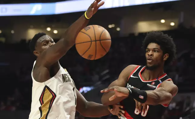 Portland Trail Blazers guard Scoot Henderson (00) passes past New Orleans Pelicans forward Zion Williamson (1) during the first half of an NBA basketball game Friday, Oct. 25, 2024, in Portland, Ore. (AP Photo/Amanda Loman)