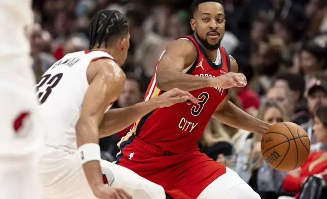 New Orleans Pelicans guard CJ McCollum, right, drives to the hoop against Portland Trail Blazers forward Toumani Camara, left, during the first half of an NBA basketball game Sunday, Oct. 27, 2024, in Portland, Ore. (AP Photo/Howard Lao)