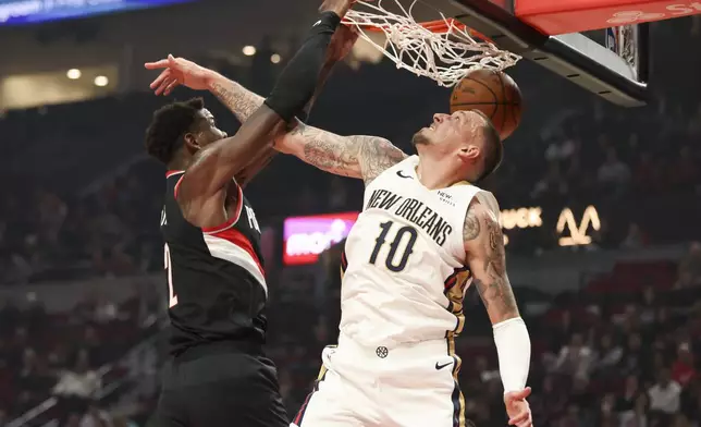 Portland Trail Blazers center Deandre Ayton, left, dunks over New Orleans Pelicans center Daniel Theis (10) during the first half of an NBA basketball game Friday, Oct. 25, 2024, in Portland, Ore. (AP Photo/Amanda Loman)