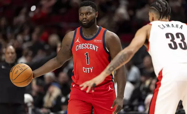 New Orleans Pelicans forward Zion Williamson, left, dribbles against Portland Trail Blazers forward Toumani Camara, right, during the second half of an NBA basketball game Sunday, Oct. 27, 2024, in Portland, Ore. (AP Photo/Howard Lao)