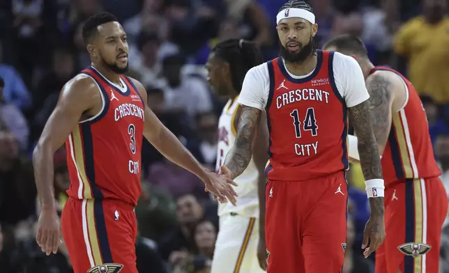 New Orleans Pelicans forward Brandon Ingram (14) is congratulated by CJ McCollum (3) after scoring against the Golden State Warriors during the first half of an NBA basketball game in San Francisco, Tuesday, Oct. 29, 2024. (AP Photo/Jed Jacobsohn)