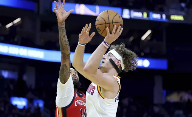 Golden State Warriors guard Brandin Podziemski, right, shoots against New Orleans Pelicans forward Brandon Ingram (14) during the first half of an NBA basketball game in San Francisco, Tuesday, Oct. 29, 2024. (AP Photo/Jed Jacobsohn)