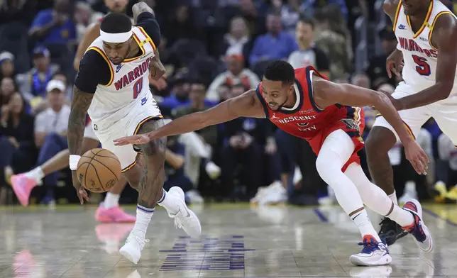 Golden State Warriors guard Gary Payton II (0) steals the ball from New Orleans Pelicans guard CJ McCollum (3) during the first half of an NBA basketball game in San Francisco, Tuesday, Oct. 29, 2024. (AP Photo/Jed Jacobsohn)