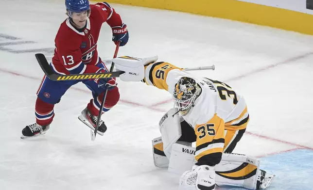 Montreal Canadiens' Cole Caufield (13) moves in on Pittsburgh Penguins goaltender Tristan Jarry during the second period of a NHL hockey game in Montreal, Monday, Oct. 14, 2024. (Graham Hughes/The Canadian Press via AP)