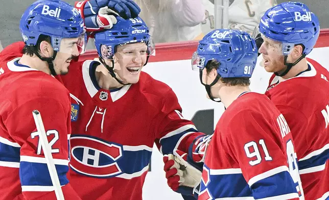 Montreal Canadiens' Emil Heineman (51) celebrates with teammates Arber Xhekaj (72), Oliver Kapanen (91) and Mike Matheson after scoring against the Pittsburgh Penguins during the second period of a NHL hockey game in Montreal, Monday, Oct. 14, 2024. (Graham Hughes/The Canadian Press via AP)