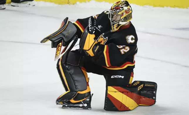 Calgary Flames goalie Dustin Wolf celebrates after defeating the Pittsburgh Penguins in an NHL hockey game on Tuesday, Oct. 22, 2024 in Calgary, Alberta. (Jeff McIntosh/The Canadian Press via AP)