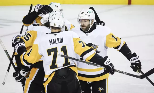 Pittsburgh Penguins' Bryan Rust, right, celebrates his goal with teammatesduring the second period of an NHL hockey game against the Calgary Flames on Tuesday, Oct. 22, 2024 in Calgary, Alberta. (Jeff McIntosh/The Canadian Press via AP)