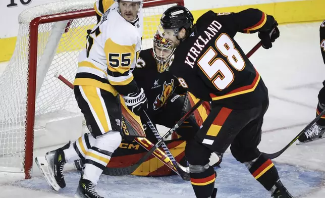 Pittsburgh Penguins' Noel Acciari, left, screens Calgary Flames goalie Dustin Wolf, center, as Justin Kirkland defends during the second period of an NHL hockey game on Tuesday, Oct. 22, 2024 in Calgary, Alberta. (Jeff McIntosh/The Canadian Press via AP)