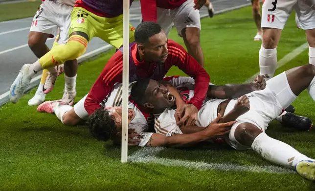 Peru's Miguel Araujo, bottom, celebrates scoring his side's opening goal against Uruguay during a qualifying soccer match for the FIFA World Cup 2026 at National Stadium in Lima, Peru, Friday, Oct. 11, 2024. (AP Photo/Guadalupe Pardo)