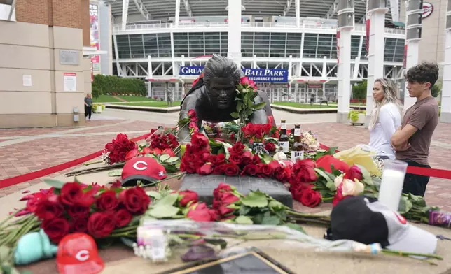 Jodi and Landon Funky, 17, right, both of Independence Ky., visit the statue of Cincinnati Reds legend Pete Rose, Tuesday, Oct. 1, 2024, in front of Great American Ball Park in Cincinnati. (AP Photo/Kareem Elgazzar)