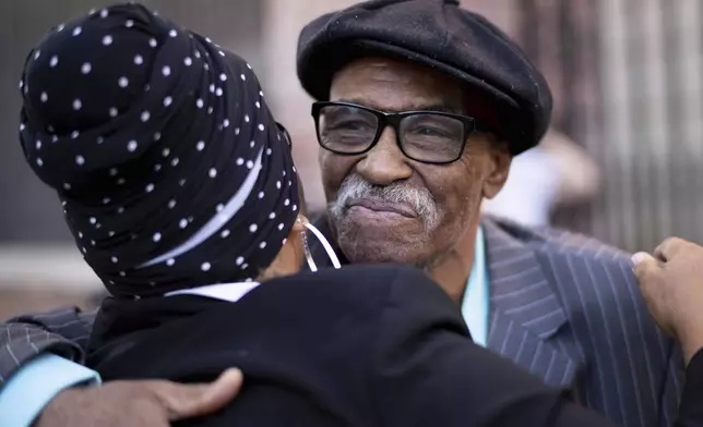 Herbert Rice, 79, right, is embraced by Adrianne Jones-Alston, on Wednesday, Oct. 23, 2024, in Philadelphia. (AP Photo/Laurence Kesterson)