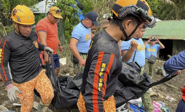 Rescuers carry a body during retrieval operations after a landslide triggered by Tropical Storm Trami, struck homes in Talisay, Batangas province, Philippines, Saturday, Oct. 26, 2024. (AP Photo/Jim Gomez)