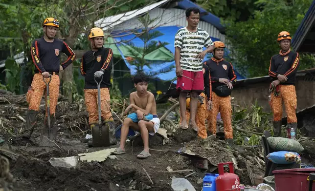 Rescuers and villagers watch retrieval operations on Saturday, Oct. 26, 2024 after it was struck by a landslide triggered by Tropical Storm Trami in Talisay, Batangas province, Philippines. (AP Photo/Aaron Favila)