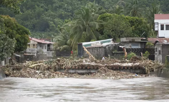 Debris from damages are gathered along a bridge after floods caused by Tropical Trami, locally named Kristine, hit Polangui, Albay province, Philippines on Oct. 23, 2024. (AP Photo/John Michael Magdasoc)