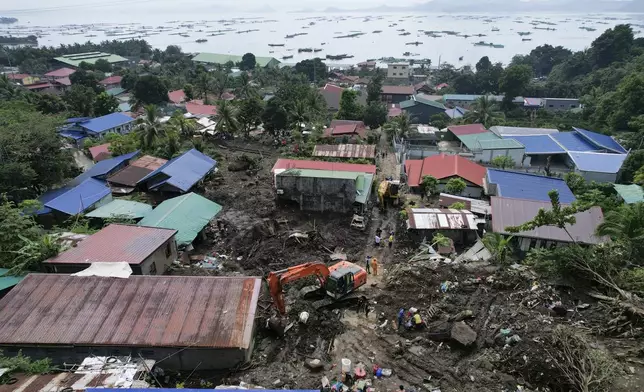 Rescuers use backhoe as they search for bodies under the rubble after a landslide triggered by Tropical Storm Trami struck homes, leaving several villagers dead in Talisay, Batangas province, Philippines Saturday, Oct. 26, 2024. (AP Photo/Aaron Favila)