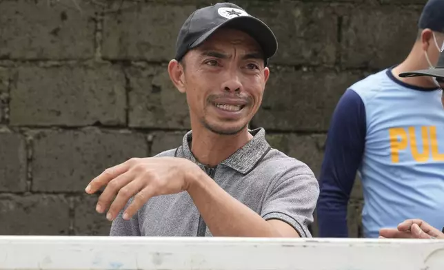 Kervin Torres grieves while rescuers recovered a body under the rubbles of a landslide after Tropical Storm Trami recently struck Talisay, Batangas province, Philippines, Saturday, Oct. 26, 2024. (AP Photo/Aaron Favila)