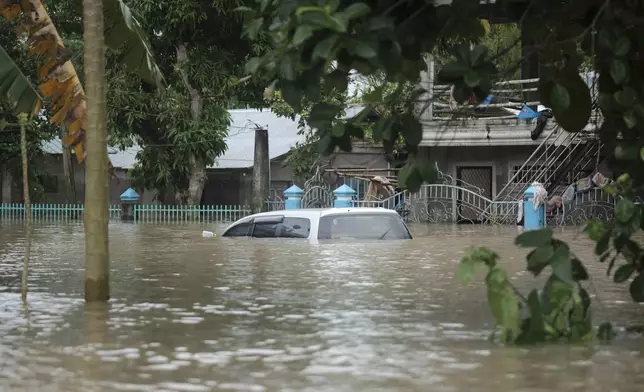 A submerged vehicle is seen in floods caused by Tropical Storm Trami, locally named Kristine, as it continues to inundate Libon town, Albay province, Philippines on Thursday Oct. 24, 2024. (AP Photo/John Michael Magdasoc)