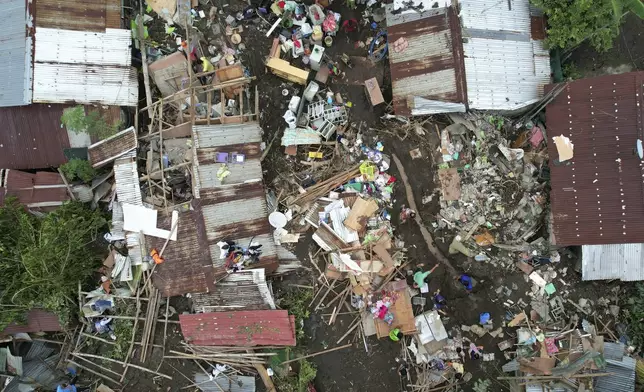 Residents gather what they can from their damaged homes on Saturday, Oct. 26, 2024 after being struck by a landslide triggered by Tropical Storm Trami in Talisay, Batangas province, Philippines. (AP Photo/Aaron Favila)