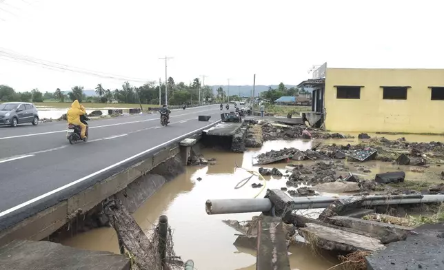 Debris from a damaged road and electric posts caused by Tropical Trami, locally named Kristine, in Polangui, Albay province, Philippines on Oct. 23, 2024. (AP Photo/John Michael Magdasoc)