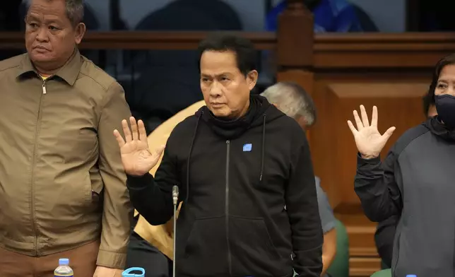 Apollo Quiboloy, a detained Filipino preacher accused of sexual abuse and human trafficking in the Philippines and similar charges in the United States, takes his oath as he attends a hearing at the Philippine Senate on Wednesday, Oct. 23, 2024, in Manila, Philippines. (AP Photo/Aaron Favila)