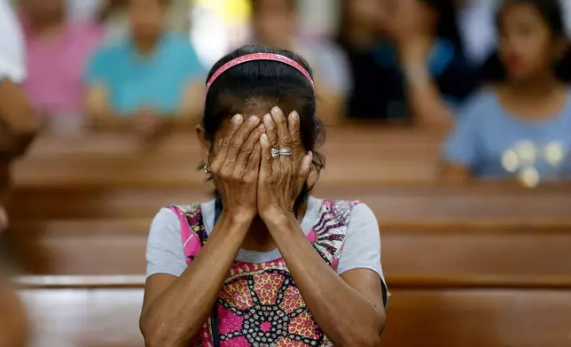 FILE - A relative of a victim in President Rodrigo Duterte's so-called war on drugs reacts during a church service in Manila, Philippines, Mach 17, 2019. (AP Photo/Bullit Marquez, File)