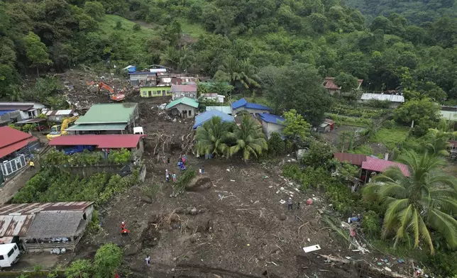 Rescuers work at the site after a recent landslide triggered by Tropical Storm Trami struck Talisay, Batangas province, Philippines, leaving thousands homeless and several villagers dead on Saturday, Oct. 26, 2024. (AP Photo/Aaron Favila)