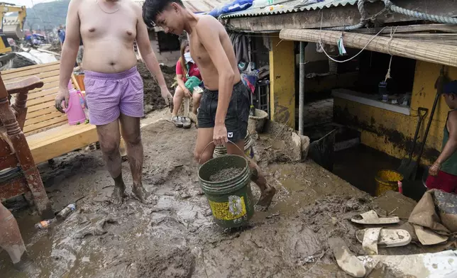 Residents clear out mud from their homes after a recent landslide triggered by Tropical Storm Trami struck Talisay, Batangas province, Philippines leaving thousands homeless and several villagers dead on Saturday, Oct. 26, 2024. (AP Photo/Aaron Favila)