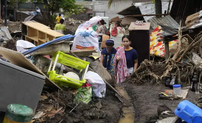 Residents try to recover belongings from their damaged homes after a recent landslide triggered by Tropical Storm Trami struck Talisay, Batangas province, Philippines leaving thousands homeless and several villagers dead on Saturday, Oct. 26, 2024. (AP Photo/Aaron Favila)