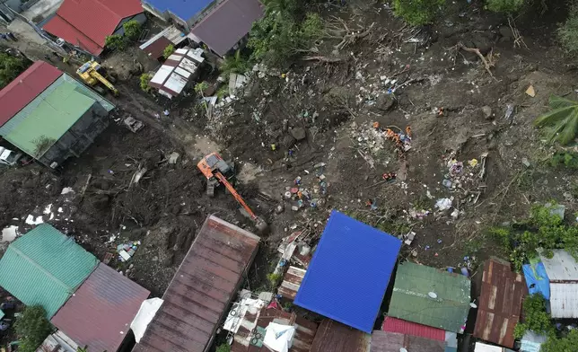 Rescuers work at the site after a recent landslide triggered by Tropical Storm Trami struck Talisay, Batangas province, Philippines leaving thousands homeless and several villagers dead on Saturday, Oct. 26, 2024. (AP Photo/Aaron Favila)