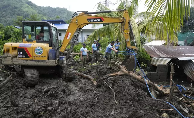 Rescuers work at the site after a recent landslide triggered by Tropical Storm Trami struck Talisay, Batangas province, Philippines leaving thousands homeless and several villagers dead on Saturday, Oct. 26, 2024. (AP Photo/Aaron Favila)