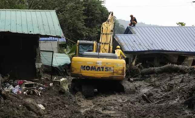 Rescuers work at the site after a recent landslide triggered by Tropical Storm Trami struck Talisay, Batangas province, Philippines leaving thousands homeless and several villagers dead on Saturday, Oct. 26, 2024. (AP Photo/Aaron Favila)