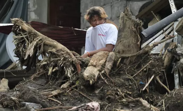 A villager watches rescue operations after a recent landslide triggered by Tropical Storm Trami struck Talisay, Batangas province, Philippines leaving thousands homeless and several villagers dead on Saturday, Oct. 26, 2024. (AP Photo/Aaron Favila)