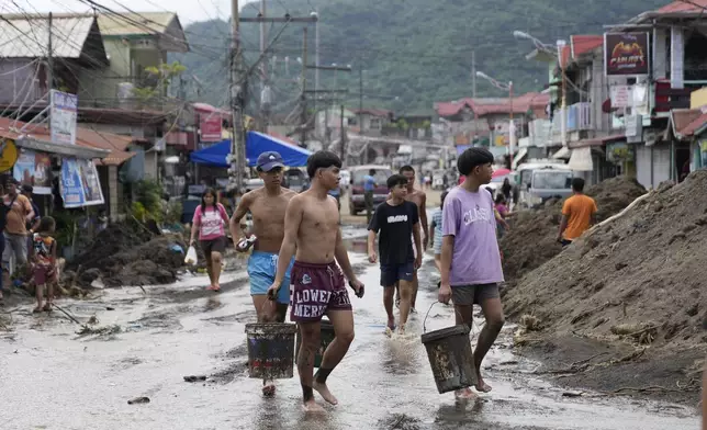 Residents clear out mud from their homes after a recent landslide triggered by Tropical Storm Trami struck Talisay, Batangas province, Philippines leaving thousands homeless and several villagers dead on Saturday, Oct. 26, 2024. (AP Photo/Aaron Favila)