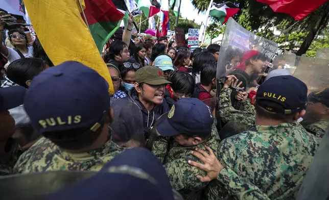 Police personnel block activists from marching near the U.S. Embassy in Manila Saturday, Oct. 5, 2024, as they hold a protest to observe the first-year anniversary of the war in Gaza. (AP Photo/Gerard V. Carreon)