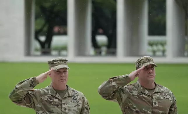 U.S. Maj. Gen. Marcus Evans, left, commanding general of the U.S. Army's 25th Infantry Division and Sgt. Major Shaun Curry salute during a wreath laying ceremony to honor American soldiers died during World War II at the Manila American Cemetery and Memorial in Taguig, Philippines Monday, Oct. 21, 2024. (AP Photo/Aaron Favila)