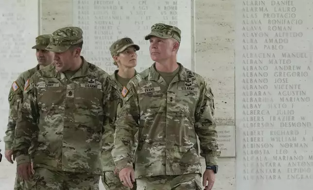 U.S. Maj. Gen. Marcus Evans, right, commanding general of the U.S. Army's 25th Infantry Division, looks at names of American soldiers who died during World War II that are carved on a wall at the Manila American Cemetery and Memorial in Taguig, Philippines on Monday, Oct. 21, 2024. (AP Photo/Aaron Favila)