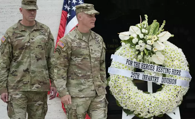 U.S. Maj. Gen. Marcus Evans, right, commanding general of the U.S. Army's 25th Infantry Division walks beside a wreath during rites to honor American soldiers died during World War II at the Manila American Cemetery and Memorial in Taguig, Philippines Monday, Oct. 21, 2024. (AP Photo/Aaron Favila)