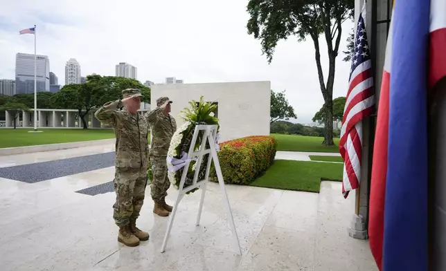 U.S. Maj. Gen. Marcus Evans, left, commanding general of the U.S. Army's 25th Infantry Division and Sgt. Major Shaun Curry salute during a wreath laying rite to honor American soldiers died during World War II at the Manila American Cemetery and Memorial in Taguig, Philippines Monday, Oct. 21, 2024. (AP Photo/Aaron Favila)