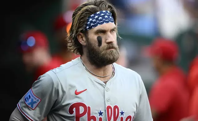 Philadelphia Phillies' Bryce Harper looks on from the dugout before a baseball game against the Washington Nationals, Saturday, Sept. 28, 2024, in Washington. (AP Photo/Nick Wass)