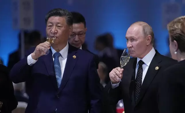 Russian President Vladimir Putin and Chinese President Xi Jinping hold glasses during a festive reception of the BRICS summit in Kazan, Russia, Wednesday, Oct. 23, 2024. (AP Photo/Alexander Zemlianichenko, Pool)