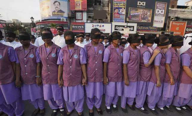 Indian nursing students wearing black ribbon over their eyes, walk with blind children during a rally on World Sight Day in Prayagraj, Uttar Pradesh, India, Thursday, Oct. 10, 2024. (AP Photo/Rajesh Kumar Singh)