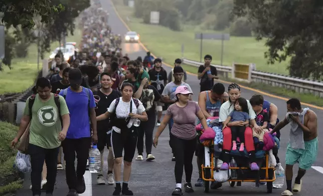 Migrants walk along the Huixtla highway in the state of Chiapas, Mexico, Tuesday, Oct. 22, 2024, hoping to reach the country's northern border and ultimately the United States. (AP Photo/Edgar H. Clemente)