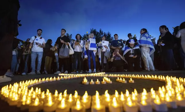 People gather for a candlelight vigil at the UCLA campus on the one-year anniversary of the Hamas attack on Israel, Monday, Oct. 7, 2024, in Los Angeles. (AP Photo/Ethan Swope)