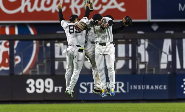 New York Yankees players Alex Verdugo, Jasson Dominguez and Trent Grisham celebrate at the end of the ninth inning of a baseball game against the Pittsburgh Pirates, Sunday, Sept. 29, 2024, in New York. (AP Photo/Eduardo Munoz Alvarez)